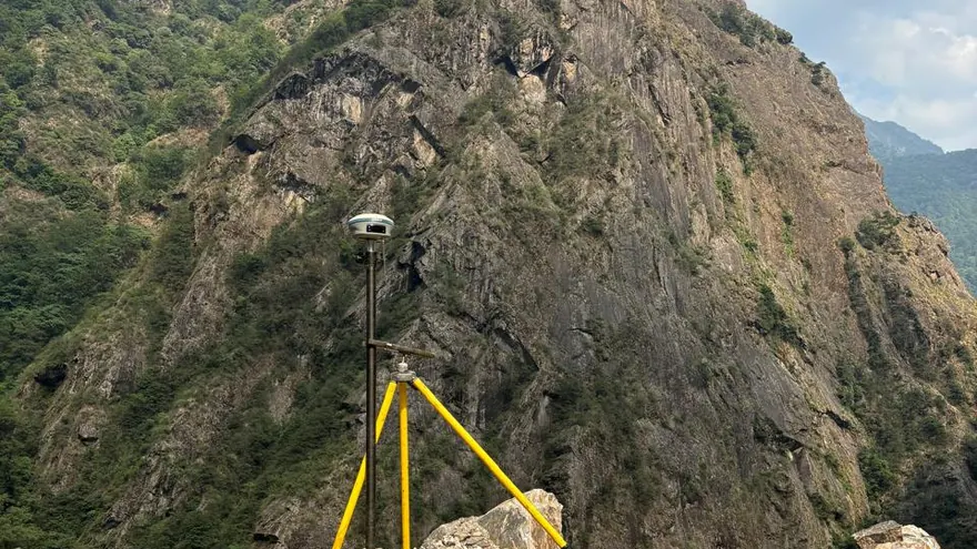 GNSS antenna set over a survey mark on steep rock — BTPL fieldwork, shown as an example of the survey type
