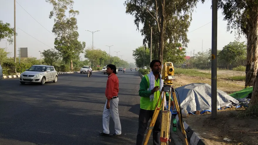 Topographic survey in progress on a road with traffic running — a representative BTPL field photograph, not from a specific PWD stretch
